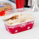 A plastic container with a Durable Packaging foil bread loaf with a clear lid.