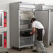 A man in a black apron opening a Beverage-Air Horizon Series reach-in freezer.