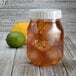 A Fineline large mason jar lid on a jar of ice tea with ice cubes and a lemon