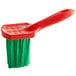 A red brush with green bristles.