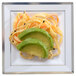 A Fineline white plastic square plate with avocado and carrot salad with silver bands.
