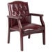 A maroon vinyl Boss executive guest chair with armrests on a white background.