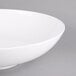 An American Metalcraft white melamine bowl with a handle on a gray surface.