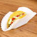 A taco in a white paper fluted Hoffmaster tray.