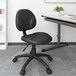 A black Boss Caressoft Diamond task chair with wheels at a desk.