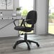 A black Boss office chair with loop arms at a desk.