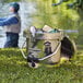 A man fishing next to a CaterGator camouflage outdoor cooler on the grass.