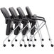 A group of four black Boss CaressoftPlus office chairs with chrome frames.