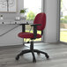 A burgundy Boss office chair with black wheels and a black base in a room.