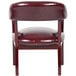 A Boss burgundy vinyl Captain's Chair with studded back and wooden legs.