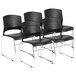 A group of four black Boss stack chairs with chrome legs.