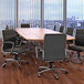 A Boss black mid-back executive chair in front of a conference table in a corporate conference room.