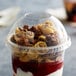 A Fabri-Kal Greenware compostable plastic dome lid on a plastic cup with yogurt, nuts, and fruit.