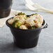 A black Fabri-Kal microwaveable side dish bowl filled with cauliflower and broccoli.