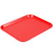 A rose red Cambro Camlite tray on a school kitchen counter.
