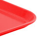 A rose red Cambro Camlite tray with a corner.