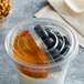 A clear Fabri-Kal plastic lid on a plastic container of yogurt with blueberries inside.