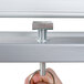 A hand adjusting the metal ring on a Luxor double-sided whiteboard stand.