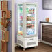 An Avantco white glass door refrigerated display case filled with drinks.