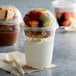 A Fabri-Kal Greenware compostable plastic parfait cup with fruit and yogurt in it.