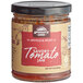A jar of TBJ Gourmet Spiced Tomato Jam on a table with a label.