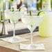 Two glasses of Finest Call Premium Lite Margarita Mix on a table with lime wedges.