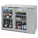 A silver Beverage-Air back bar refrigerator with glass doors filled with bottles of beer.