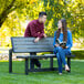 A man and woman sitting on a Lifetime convertible bench with a woman reading a book.