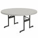 A round Lifetime putty plastic folding table with black legs.