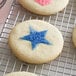 Light blue sanding sugar sprinkled on a cookie with a blue star on it.