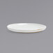 A white Front of the House Artefact porcelain plate with a gold rim on a gray surface.