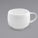 A close up of the front of a white porcelain cup with a handle.