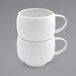 A stack of two Front of the House white spiral porcelain coffee cups with handles.