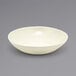 A Front of the House vanilla bean porcelain bowl on a gray surface.