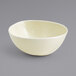A close up of a Front of the House Vanilla Bean round porcelain bowl on a gray surface.