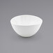 A case of 12 white Front of the House Kiln porcelain bowls on a gray surface.