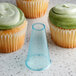 A cupcake with green frosting piped on top using an Ateco plain piping tip.