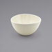 A Front of the House Kiln vanilla bean porcelain bowl on a gray surface.