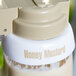 A white Tablecraft salad dressing dispenser collar with beige lettering that says "Honey Mustard" on it.