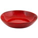 A red porcelain bowl with black specks.