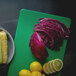 A Vollrath cutting board system with corn, red cabbage, and a lemon on it.