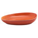 A blood orange porcelain oval plate with a curved edge.