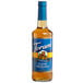 A Torani Sugar-Free Classic Hazelnut flavoring syrup in a glass bottle with a blue label.
