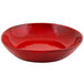 A red bowl with a shiny surface and black specks.
