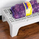 A bag of purple onions on a Cambro slotted top dunnage rack.