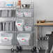 A Rubbermaid metal shelving unit with 5 white ingredient bins.
