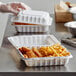 A white Ecopax take-out container with fried food in it.