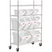 A metal shelving unit with white bins on wheels.