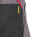 A person wearing a black Uncommon Chef Rebel apron with a pencil in the front pocket.