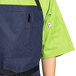 A person wearing a blue denim Uncommon Chef bib apron over a green shirt.